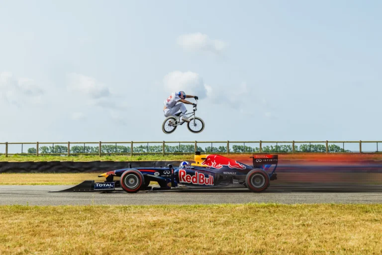 Kriss Kyle hopper en BMX -cykel over en bevægelig F1 -bil drevet af David Coulthard